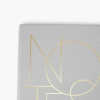 Close-up of gold foil NOTES lettering on grey luxury notebook
