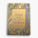 Grey hardcover A5 notebook with gold translucent text: “Never lose your sense of wonder.”