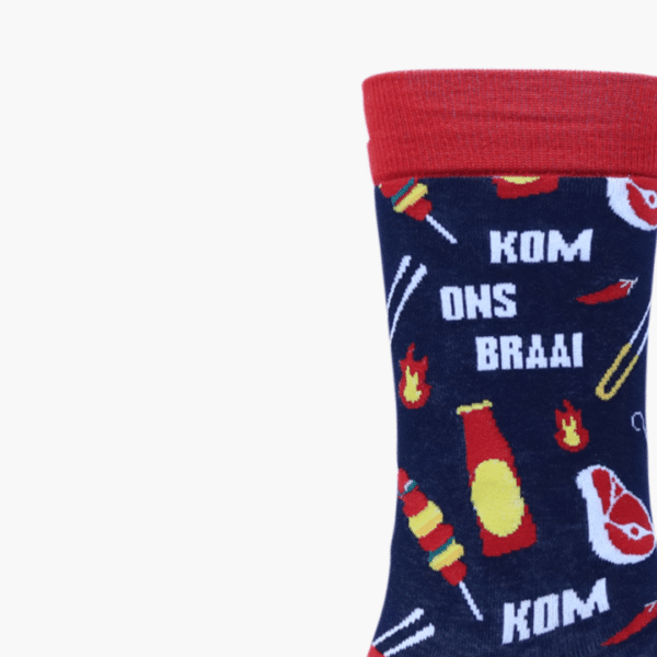 Close up Funky Sock Doctor socks with “Kom Ons Braai” text and steak, meat, and braai sauce illustrations