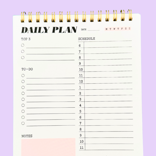 Close-up of pink A5 daily planner top 3 priorities and date sections